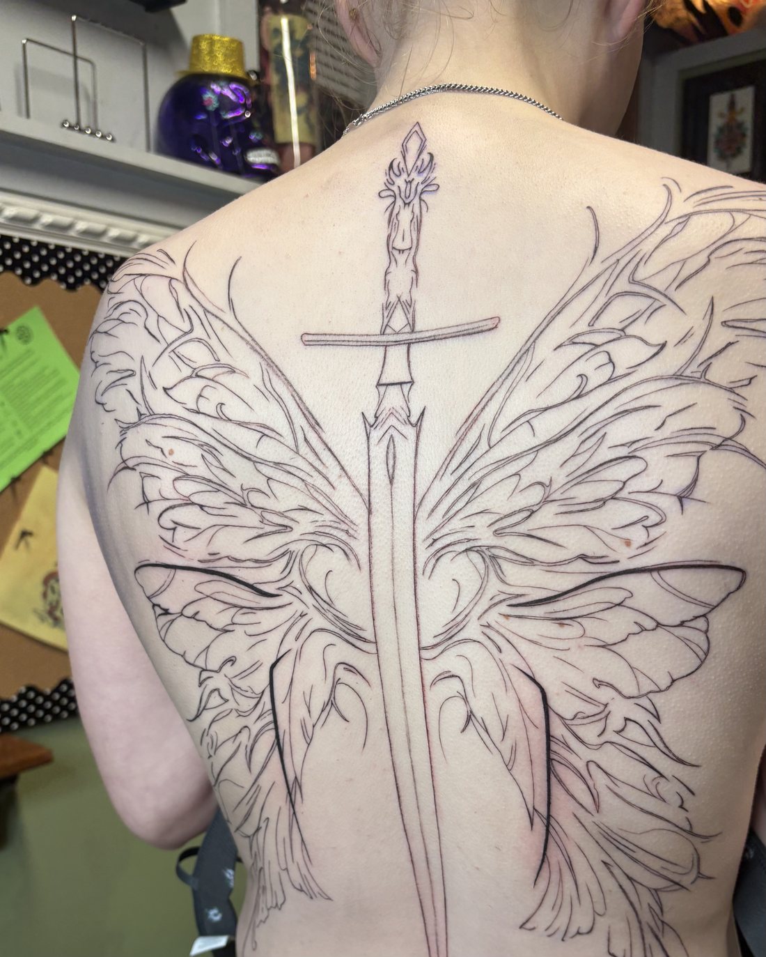 Large-scale custom back piece in progress, sword and wings fine-line design